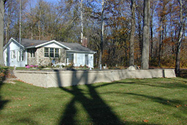 Surface fountain on an elevated terrace bounded by a retaining wall.