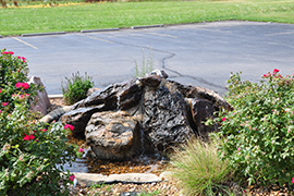 Corner landscape area with rock fountain.